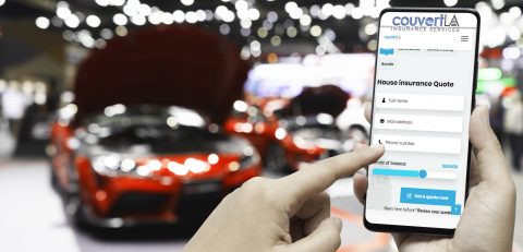 Mockup image of hand holding blank screen mobile and pointing to smart phone with blurred background of new cars display in showroom, buying new car. Mock up smartphone for your advertisement.